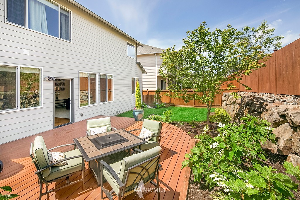 3815 222nd Place Southeast Bothell, WA 98021 - Photo 17 of 20 a view of a patio with table and chairs with wooden fence and plants