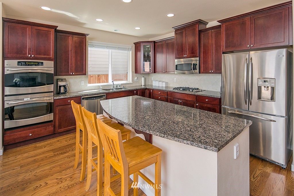 3815 222nd Place Southeast Bothell, WA 98021 - Photo 6 of 20 a kitchen with stainless steel appliances granite countertop a refrigerator a stove top oven a sink and dishwasher
