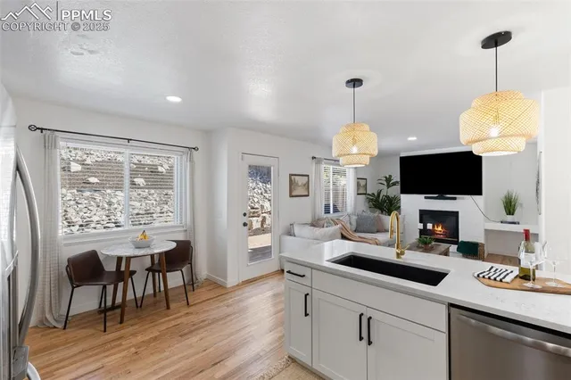 a kitchen with stainless steel appliances granite countertop a refrigerator a stove a sink dishwasher and a refrigerator with wooden floor