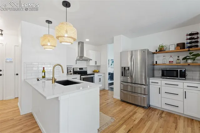 a kitchen with stainless steel appliances a stove a sink and a refrigerator