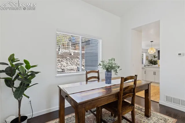 a view of a dining room with furniture a chandelier and wooden floor