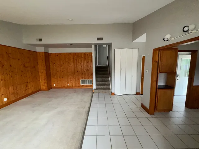 an empty room with windows and a ceiling fan