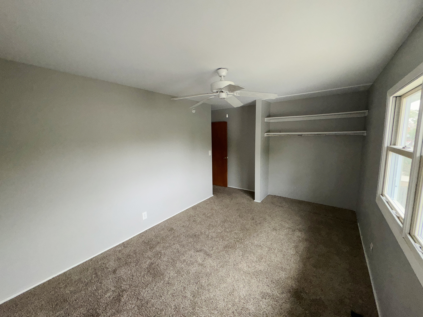 1612 Golfview Road Rantoul, IL 61866 - Photo 29 of 46 an empty room with windows and chandelier fan