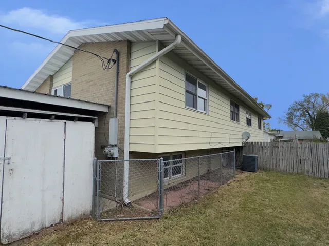 a view of small house with wooden fence