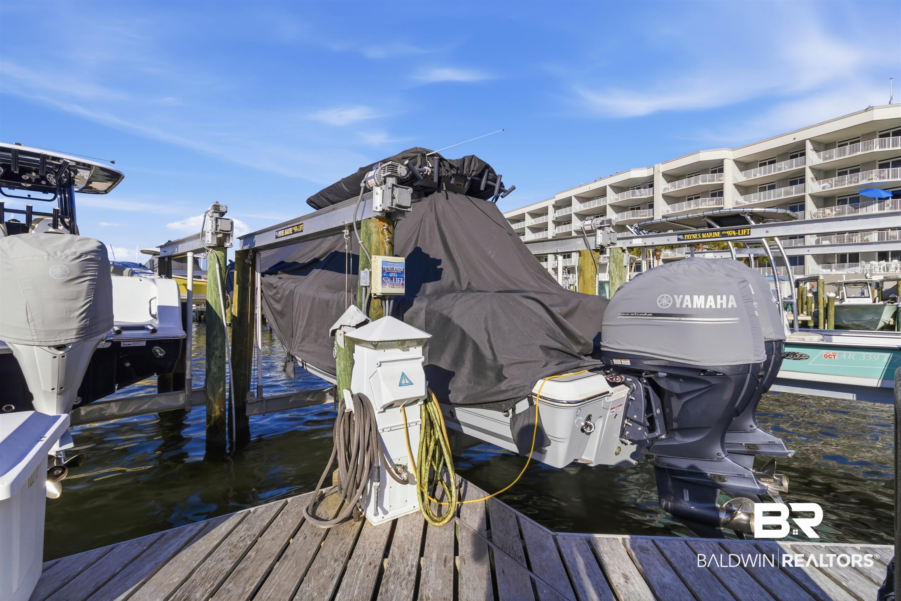 3564 Bayou Road, Unit 203 Orange Beach, AL 36561 - Photo 44 of 53 Dockside boat lift featuring a wooden pier, power pedestals, and marine pilings