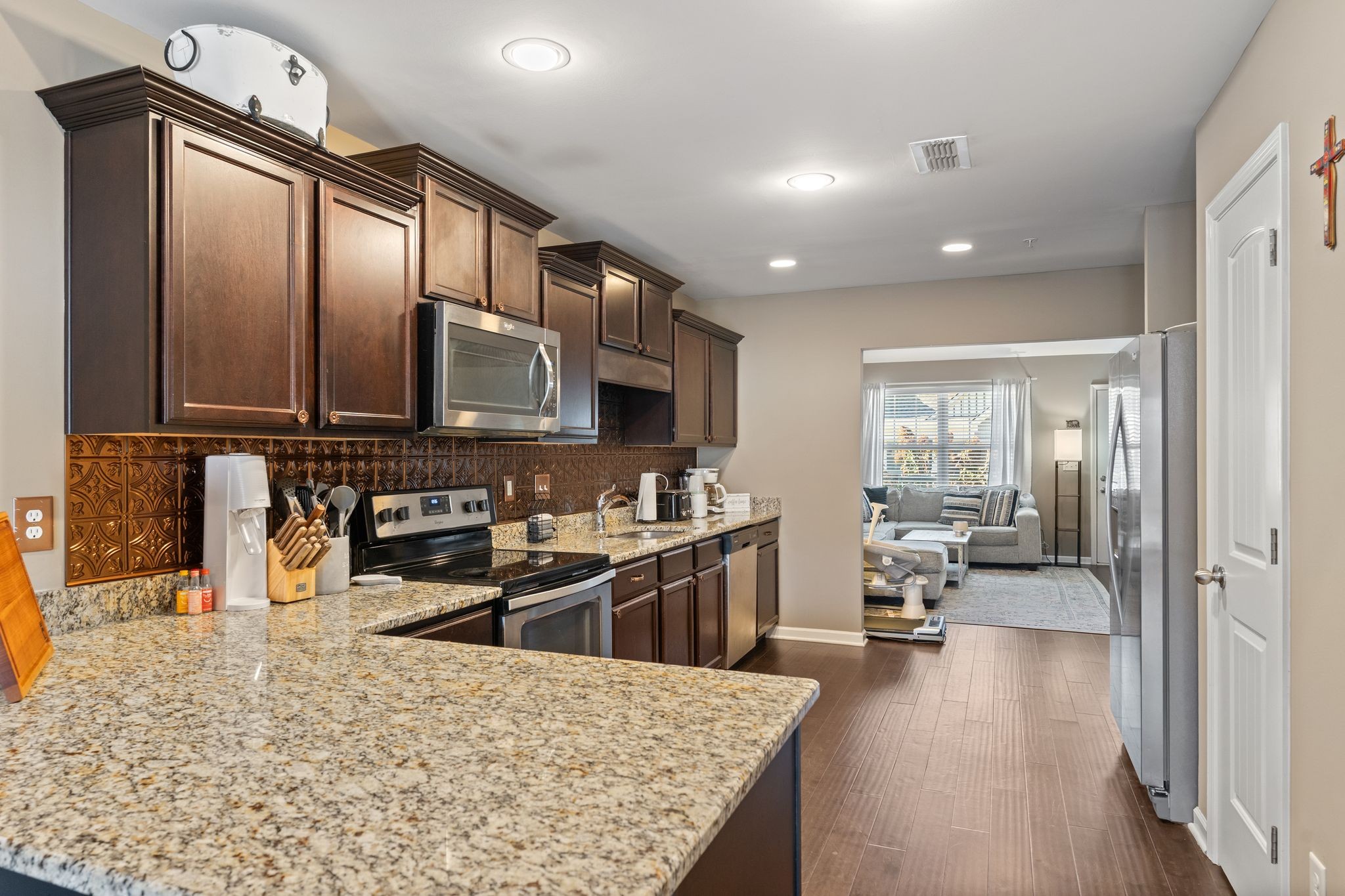 4020 Commons Drive Spring Hill, TN 37174 - Photo 10 of 37 a kitchen with stainless steel appliances granite countertop a sink stove and wooden cabinets