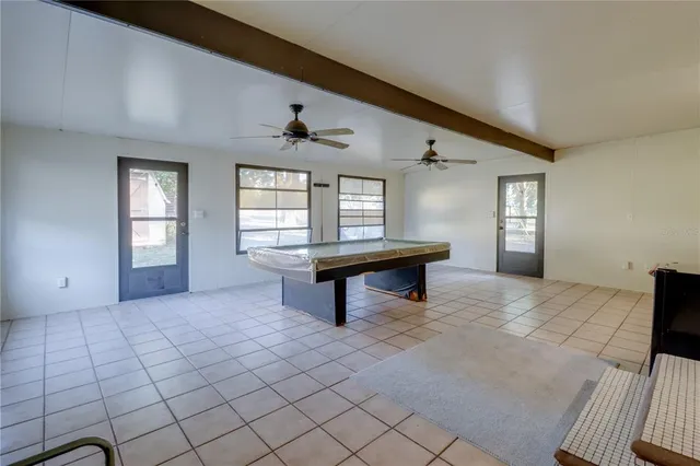 a yellow and red house with a flower garden in front of it