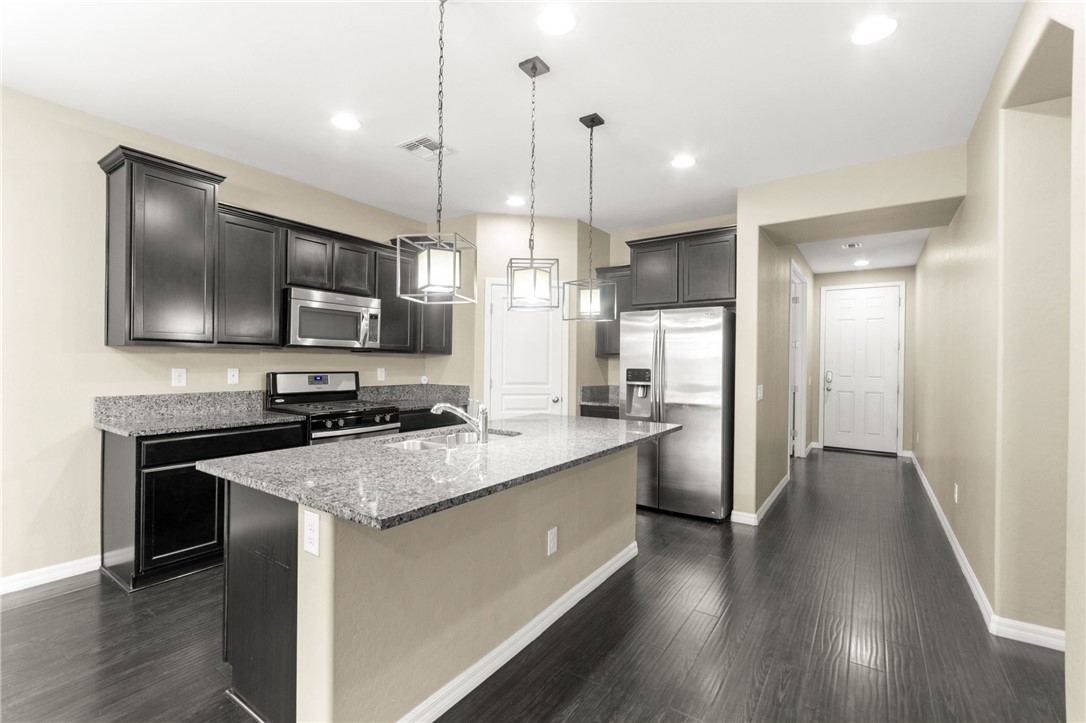 11048 Prairie Grove Road Las Vegas, NV 89179 - Photo 15 of 75 Culinary adventures await in this kitchen, boasting an island, ample dark cabinetry, and sleek appliances.