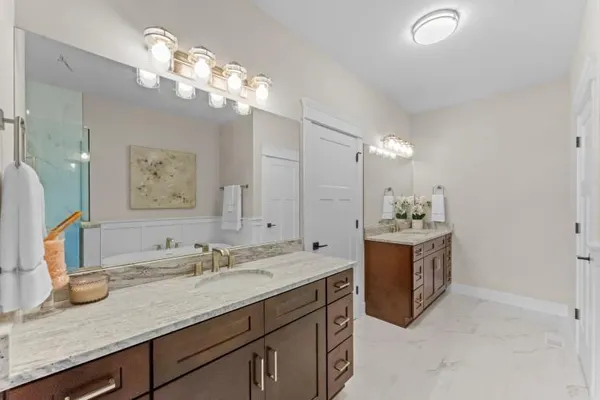 a bathroom with a granite countertop double vanity sink and a mirror