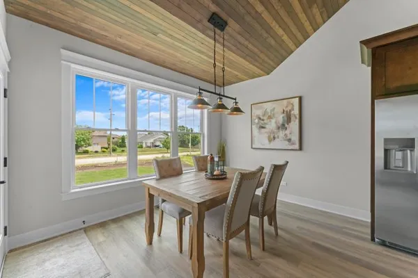 a dining room with furniture a chandelier and wooden floor