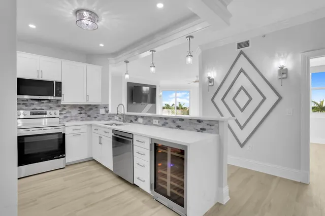 a kitchen with stainless steel appliances granite countertop a stove top oven a sink and a microwave