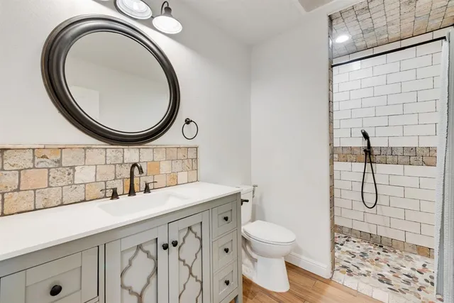 a bathroom with a sink a toilet and a mirror