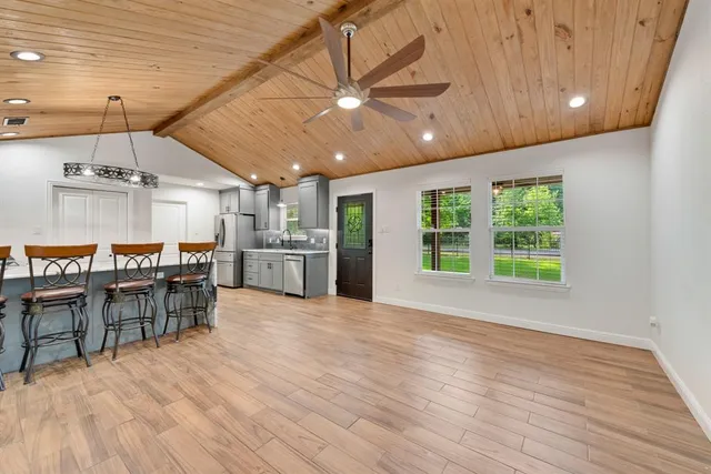 a open kitchen with kitchen island a stove and a wooden floors