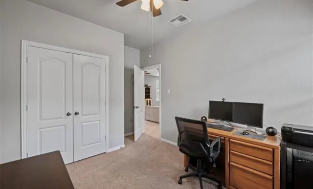 a view of a workspace with furniture and a window