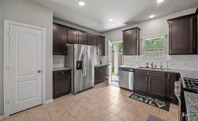 a kitchen with stainless steel appliances granite countertop a refrigerator and a sink