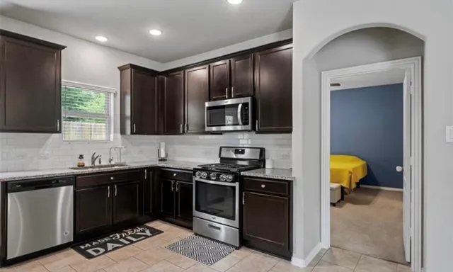 a kitchen with a sink stainless steel appliances and cabinets