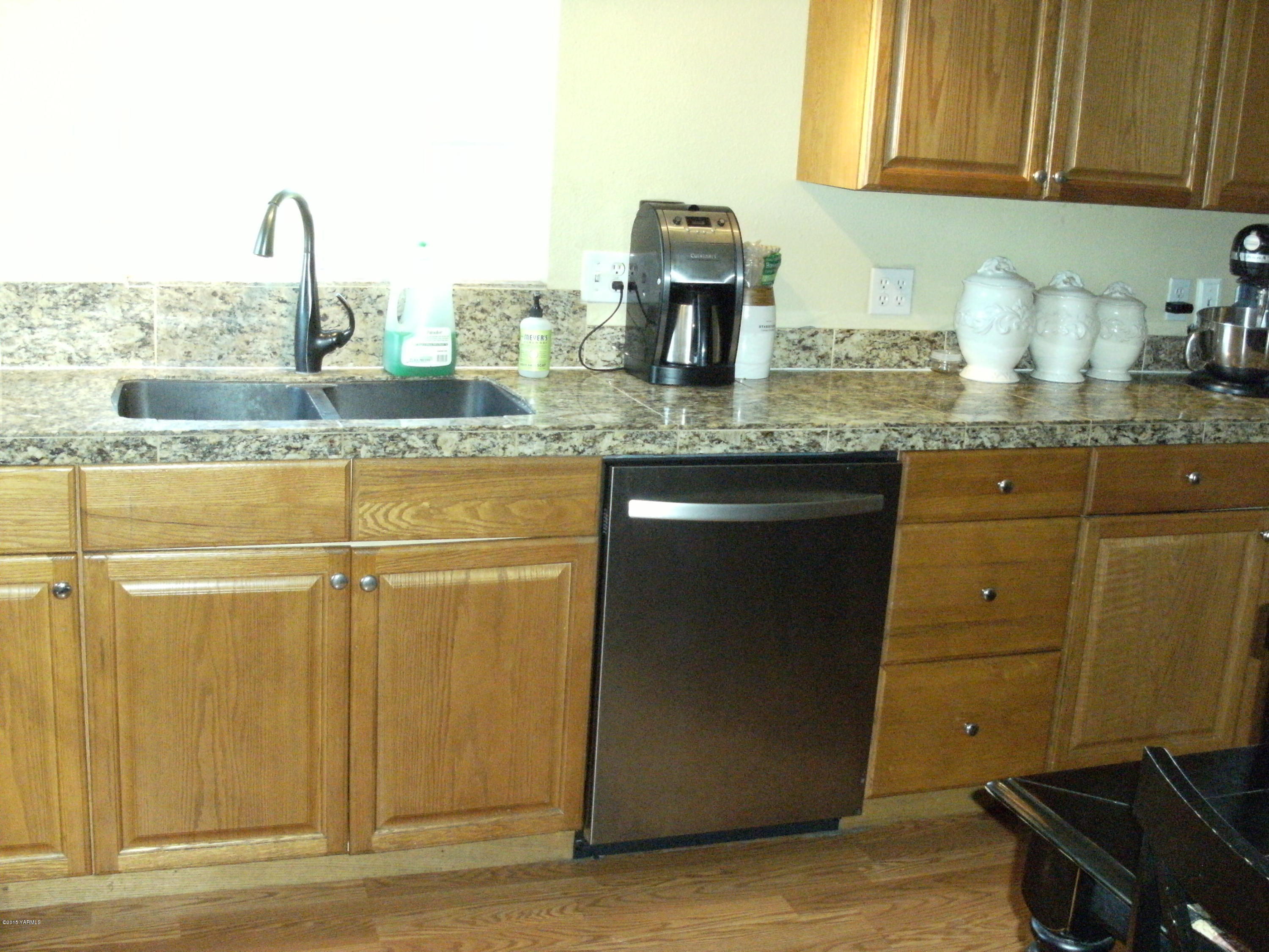 1180 Woodworth Road Grandview, WA 98930 - Photo 2 of 26 a kitchen with sink cabinets and a window