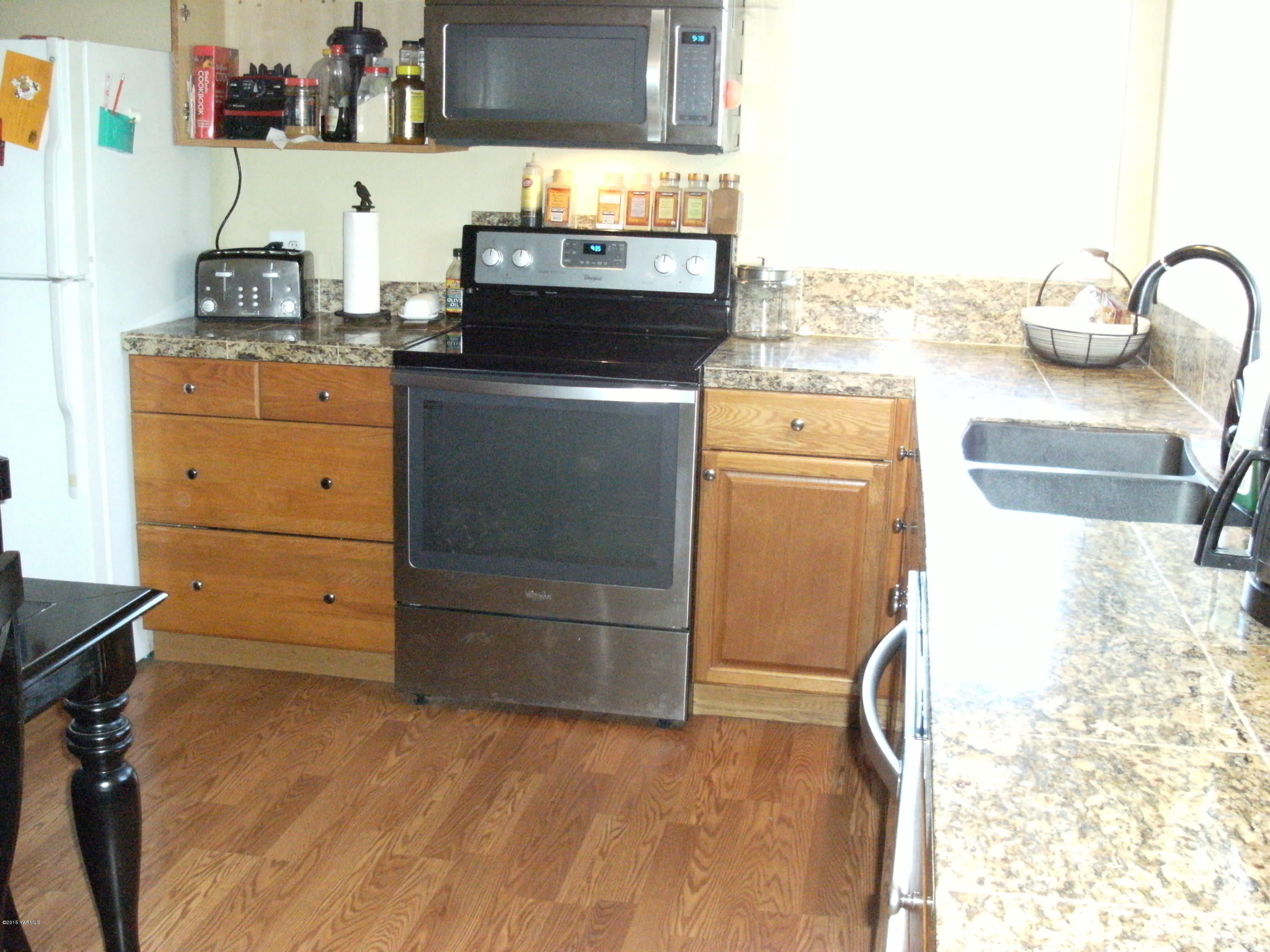 1180 Woodworth Road Grandview, WA 98930 - Photo 3 of 26 a kitchen with a sink and a stove