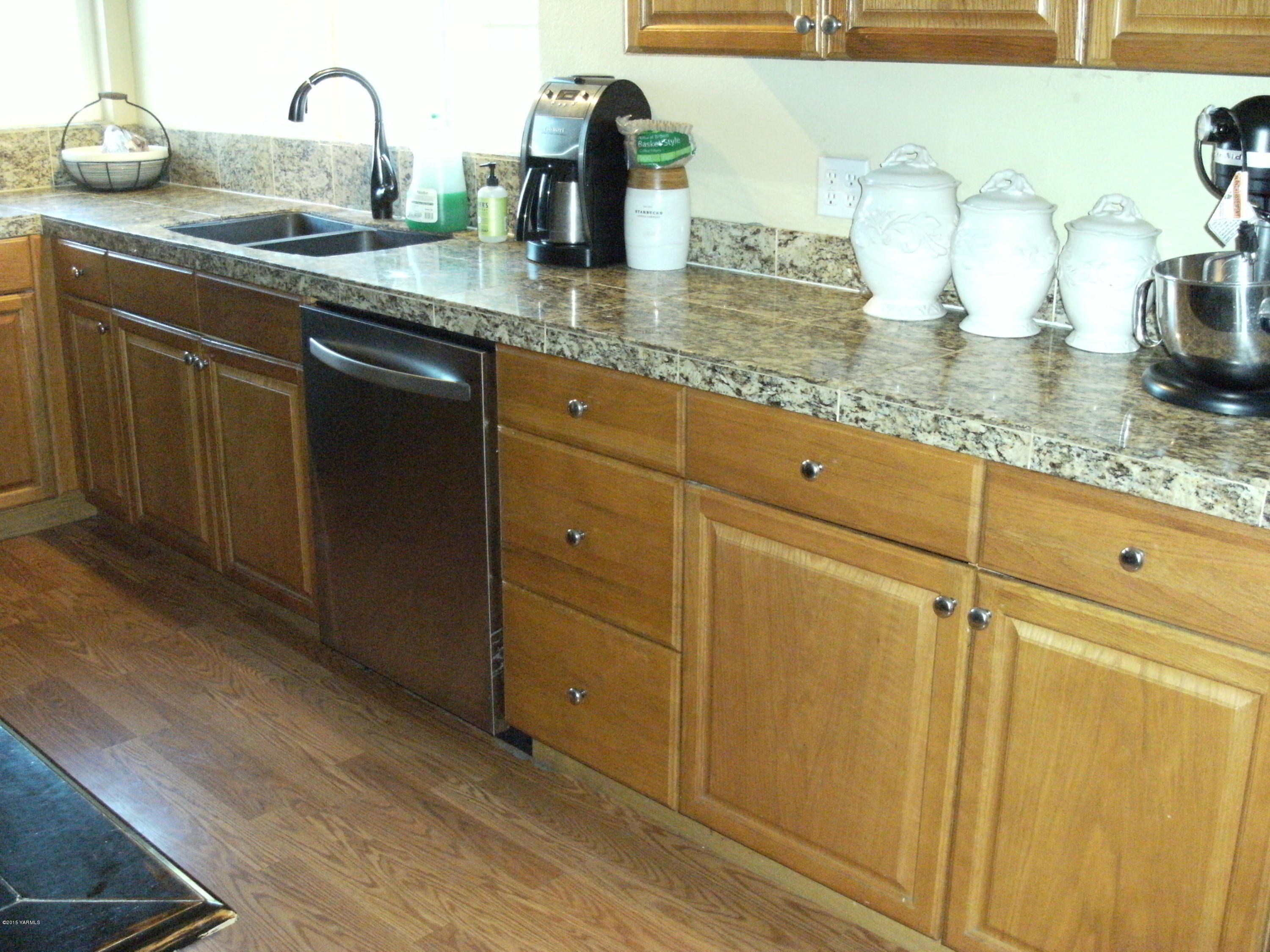 1180 Woodworth Road Grandview, WA 98930 - Photo 4 of 26 a kitchen with granite countertop a sink and cabinets