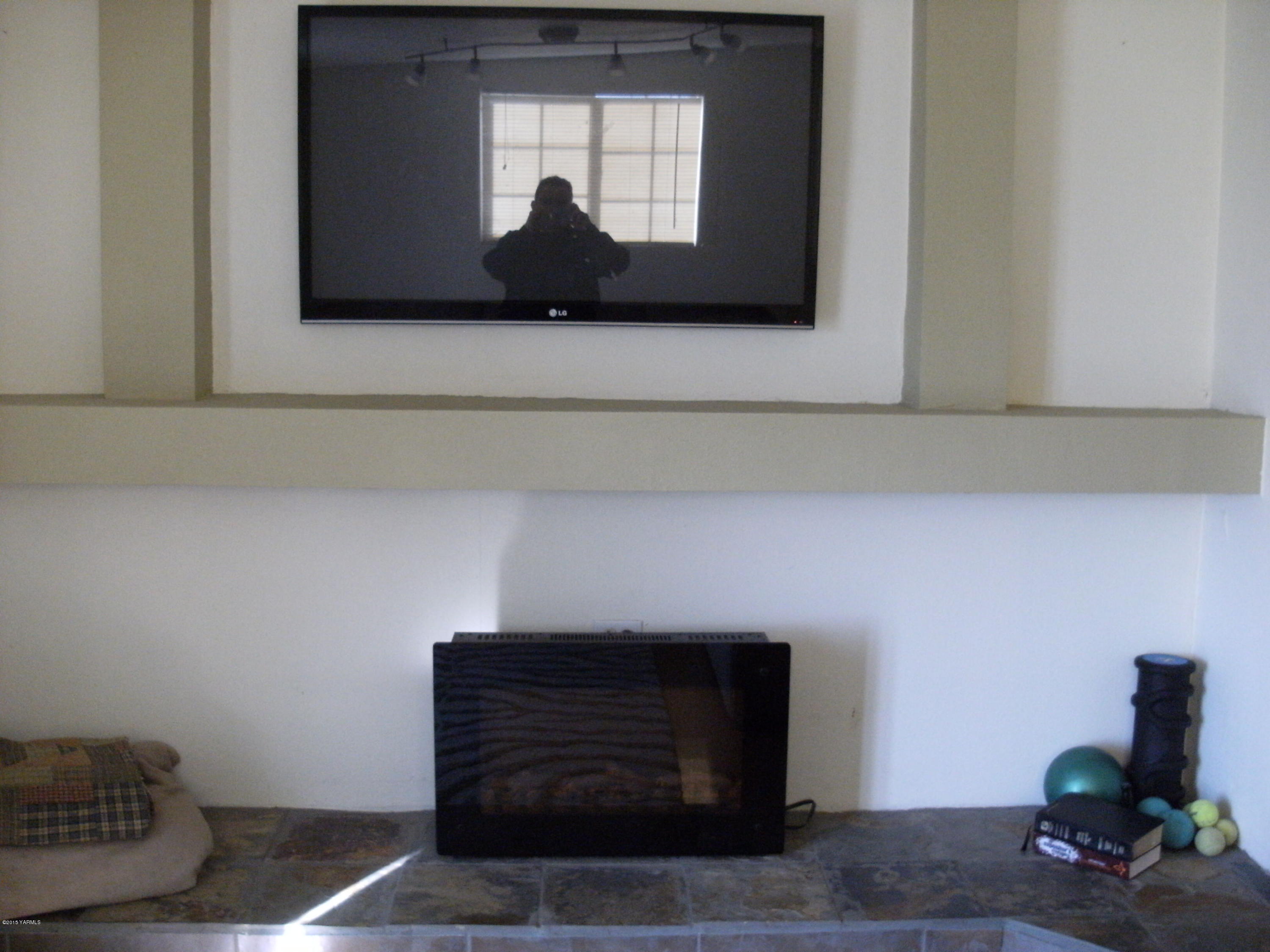 1180 Woodworth Road Grandview, WA 98930 - Photo 5 of 26 a living room with a fireplace and a potted plant