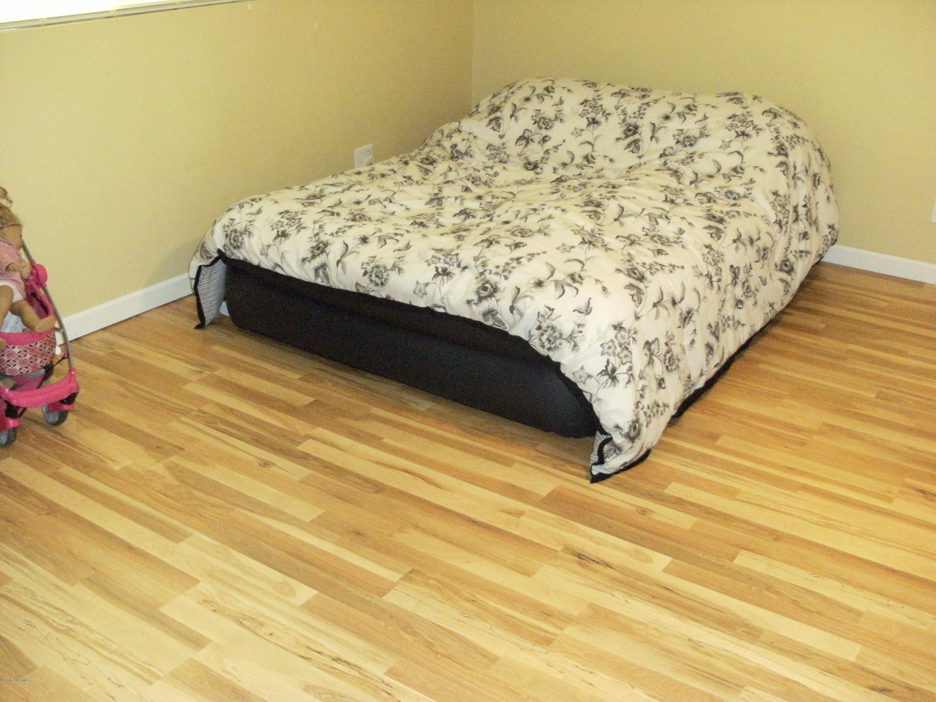 1180 Woodworth Road Grandview, WA 98930 - Photo 10 of 26 a bed sitting in a bedroom next to a wall