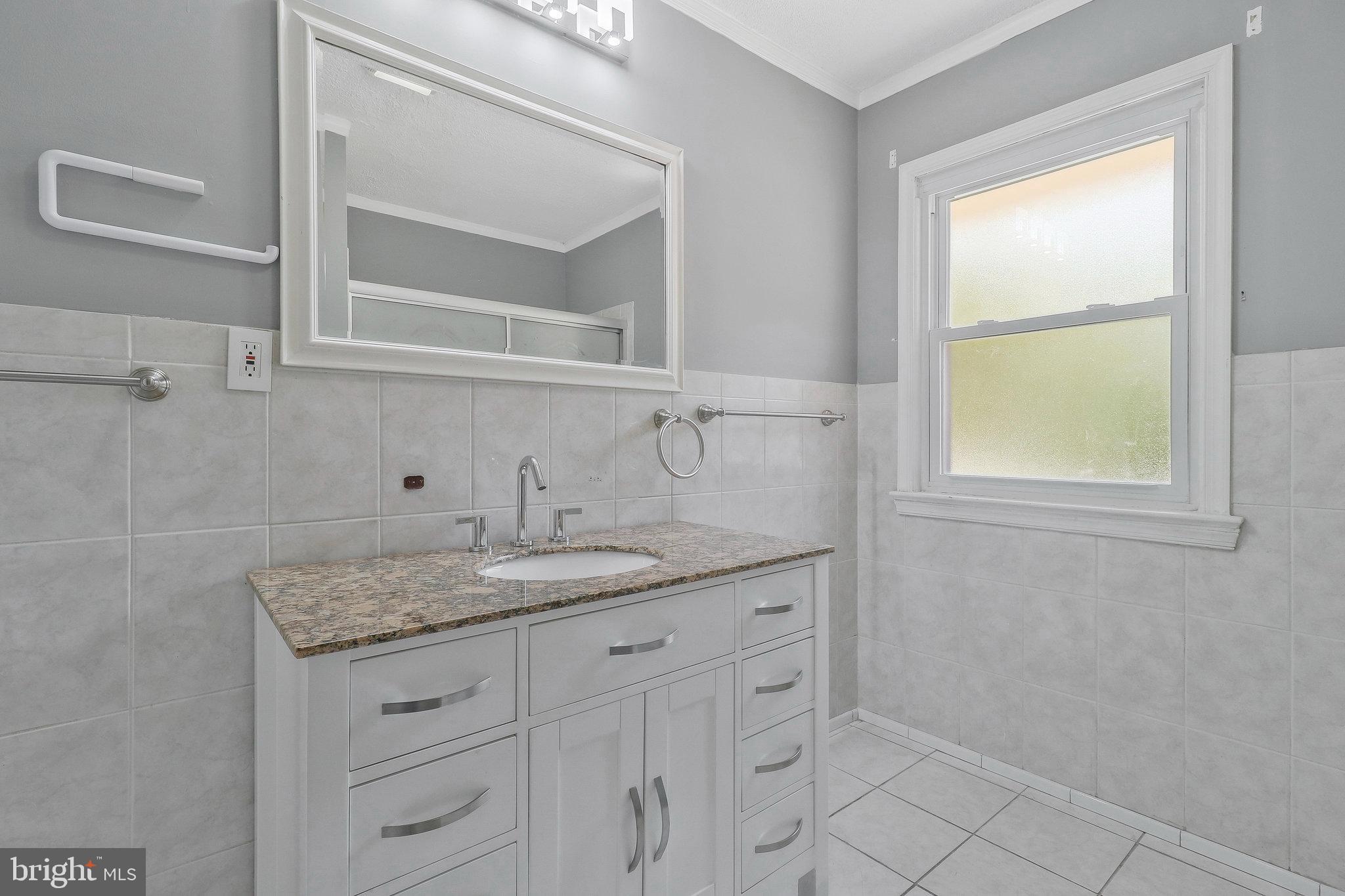 9600 Woodland Avenue Lanham, MD 20706 - Photo 17 of 41 a bathroom with a granite countertop sink and a window