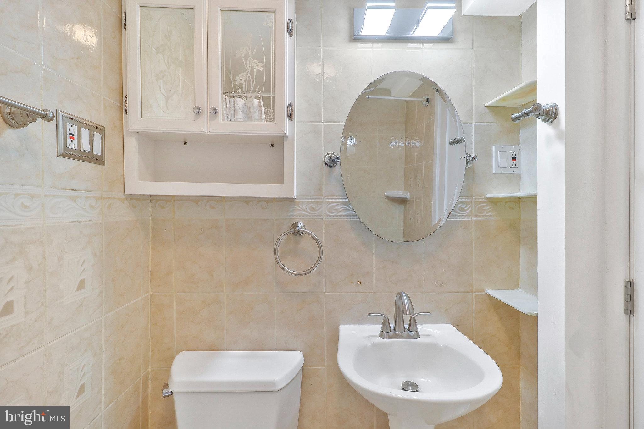 9600 Woodland Avenue Lanham, MD 20706 - Photo 34 of 41 a bathroom with a sink a toilet and a mirror