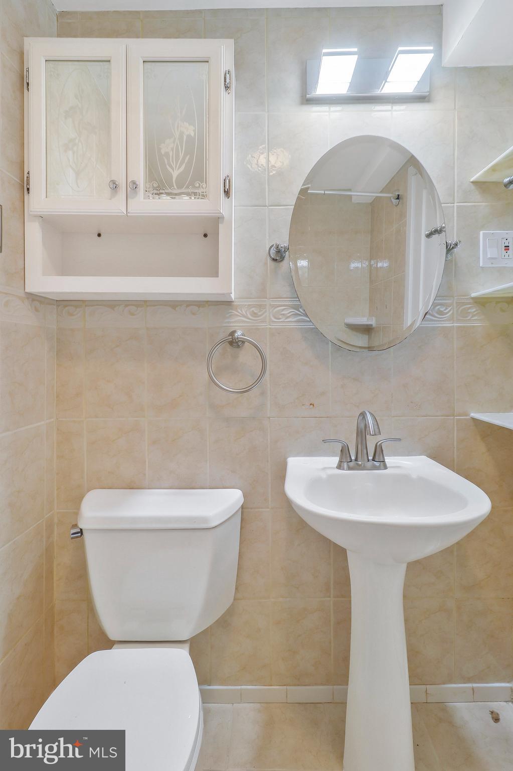 9600 Woodland Avenue Lanham, MD 20706 - Photo 35 of 41 a bathroom with a toilet sink and mirror