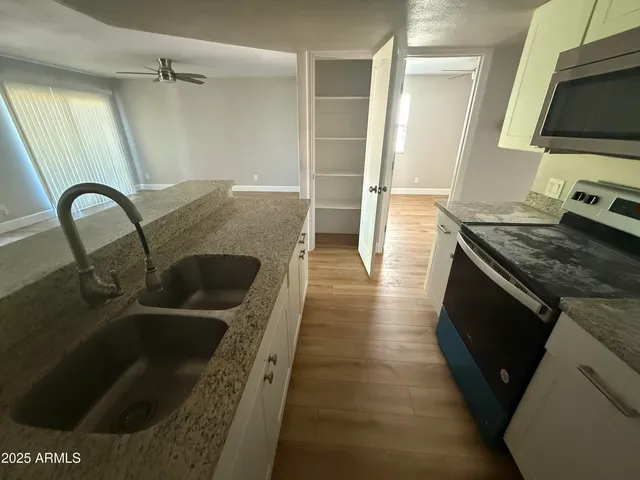 a kitchen with stainless steel appliances granite countertop a stove a microwave and a sink