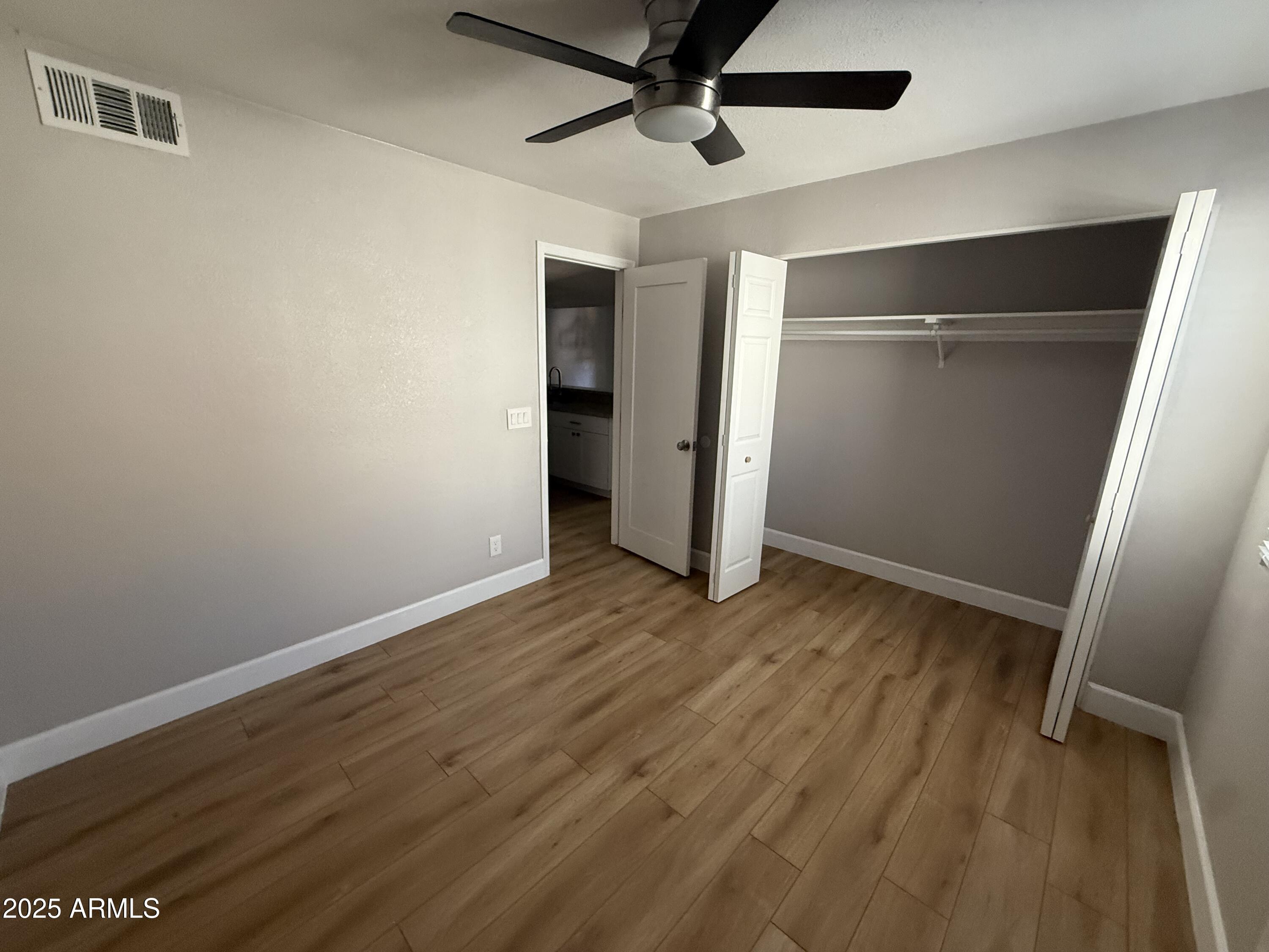 8801 North 8th Street, Unit 203 Phoenix, AZ 85020 - Photo 15 of 29 a view of a room with wooden floor and a ceiling fan