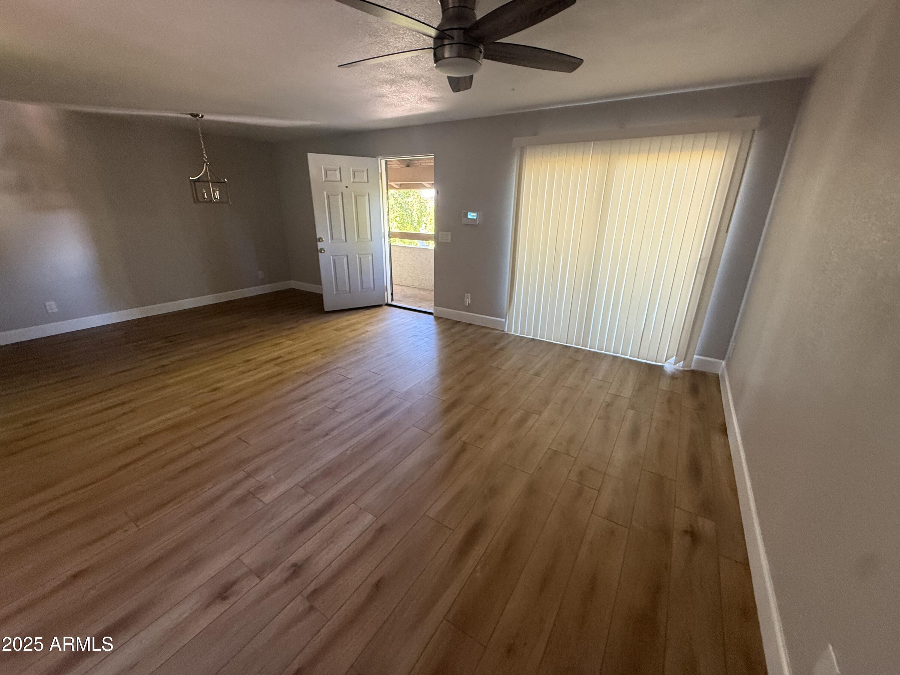 8801 North 8th Street, Unit 203 Phoenix, AZ 85020 - Photo 10 of 29 an empty room with wooden floor and windows