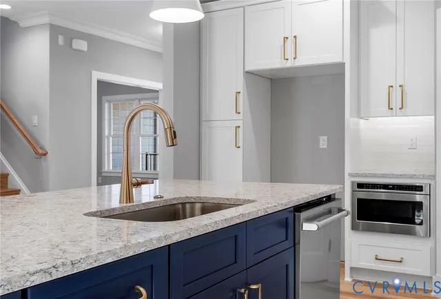 a kitchen with stainless steel appliances granite countertop a sink and a refrigerator