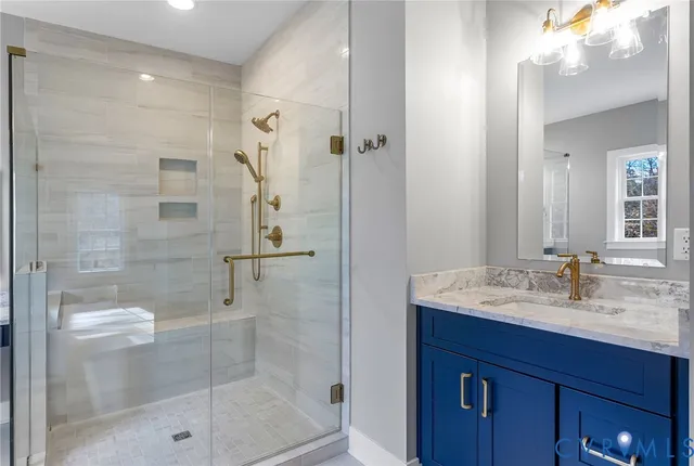 a bathroom with a shower sink vanity and mirror