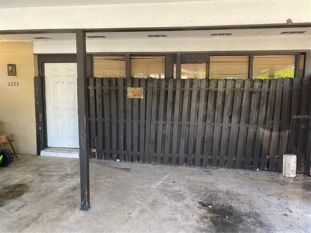 a view of a house with a wooden fence