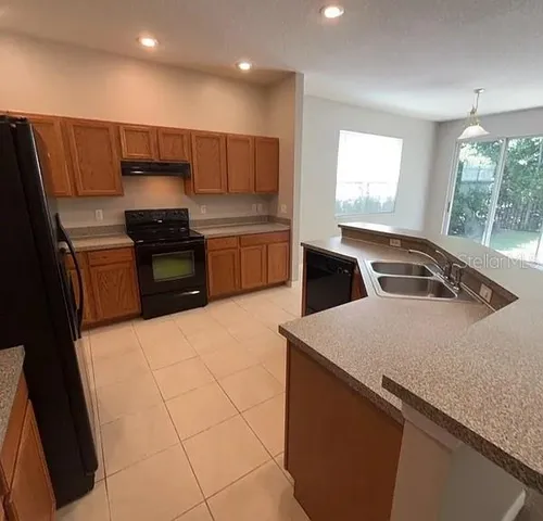 a kitchen with stainless steel appliances a refrigerator sink and stove