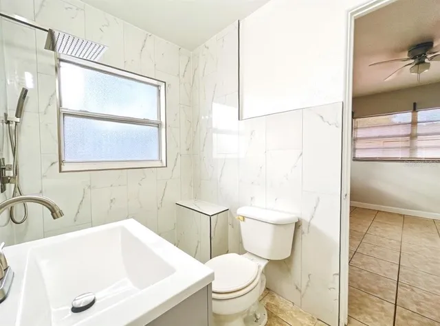 a view of a kitchen with refrigerator and white cabinets