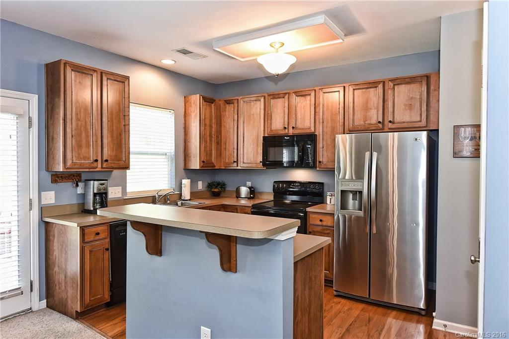142 Whitley Mills Road Fort Mill, SC 29708 - Photo 7 of 24 a kitchen with stainless steel appliances granite countertop a refrigerator a sink dishwasher a stove and white cabinets with wooden floor