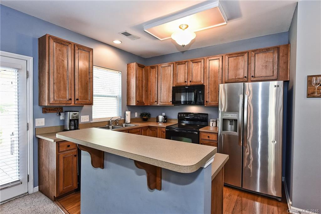 142 Whitley Mills Road Fort Mill, SC 29708 - Photo 8 of 24 a kitchen with wooden cabinets a sink a stove and refrigerator