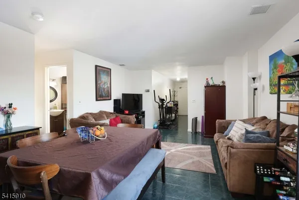 a living room with furniture a flat screen tv and a dining table