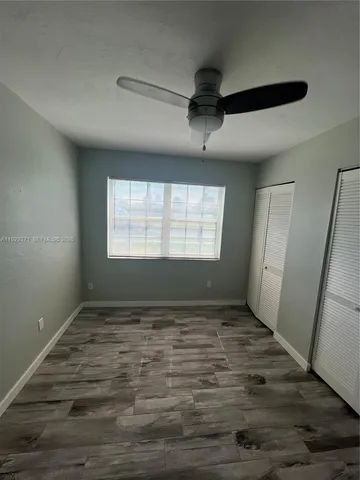a view of empty room with window and ceiling fan