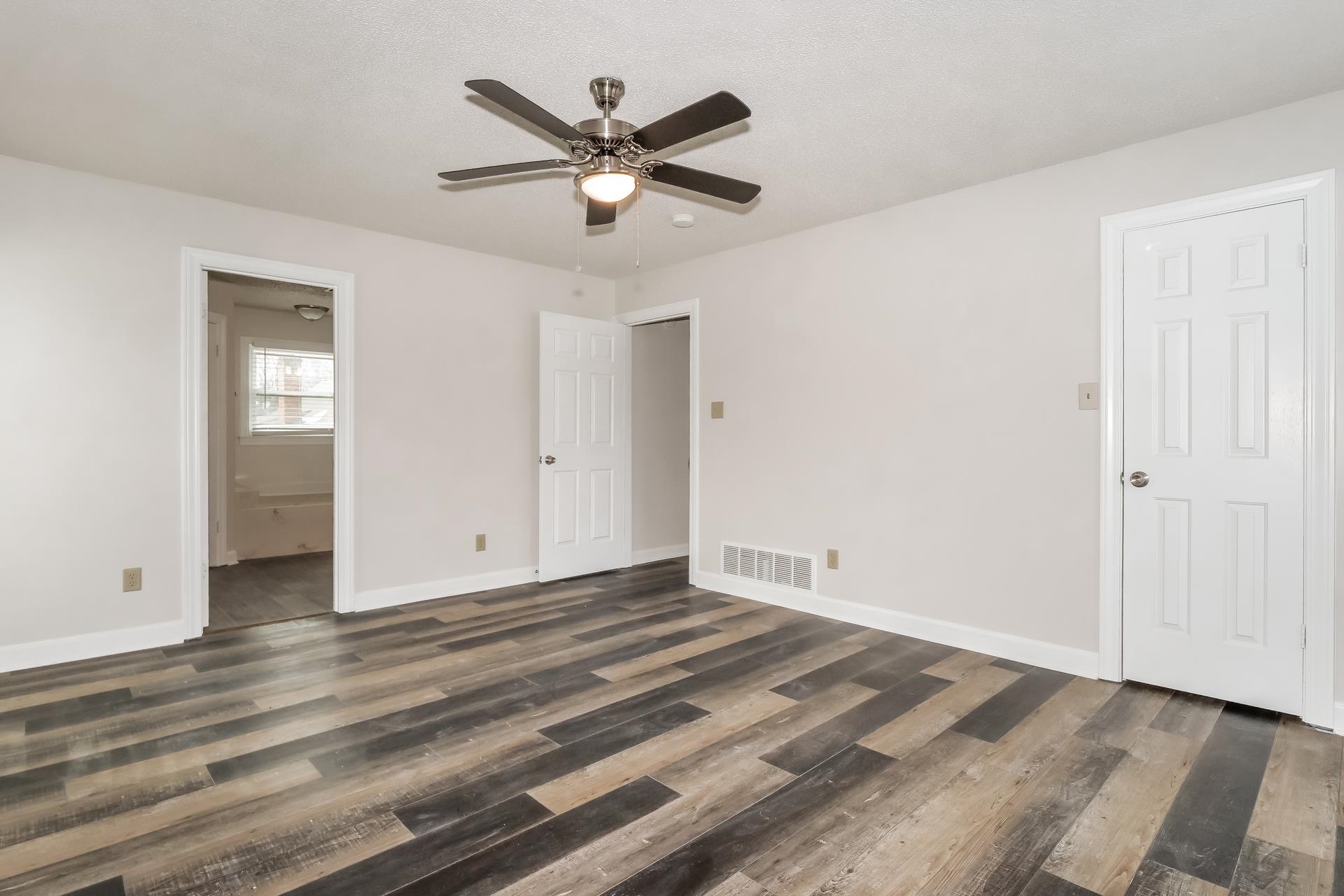 675 South Collierville Arlington Road Collierville, TN 38017 - Photo 6 of 17 Unfurnished bedroom featuring dark wood-style flooring, a ceiling fan, and ensuite bath