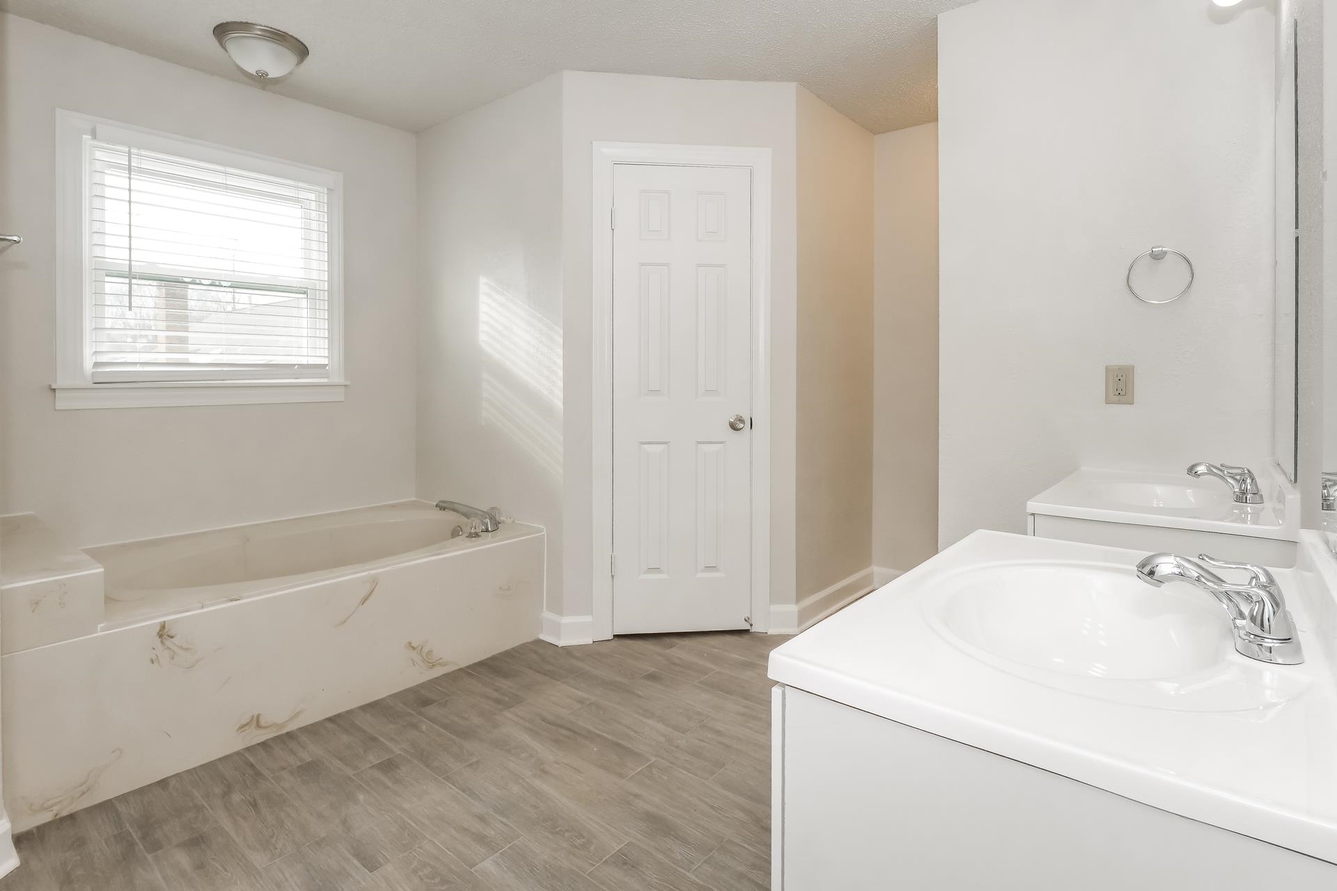675 South Collierville Arlington Road Collierville, TN 38017 - Photo 8 of 17 Bathroom with vanity, a bath, and light wood-style floors