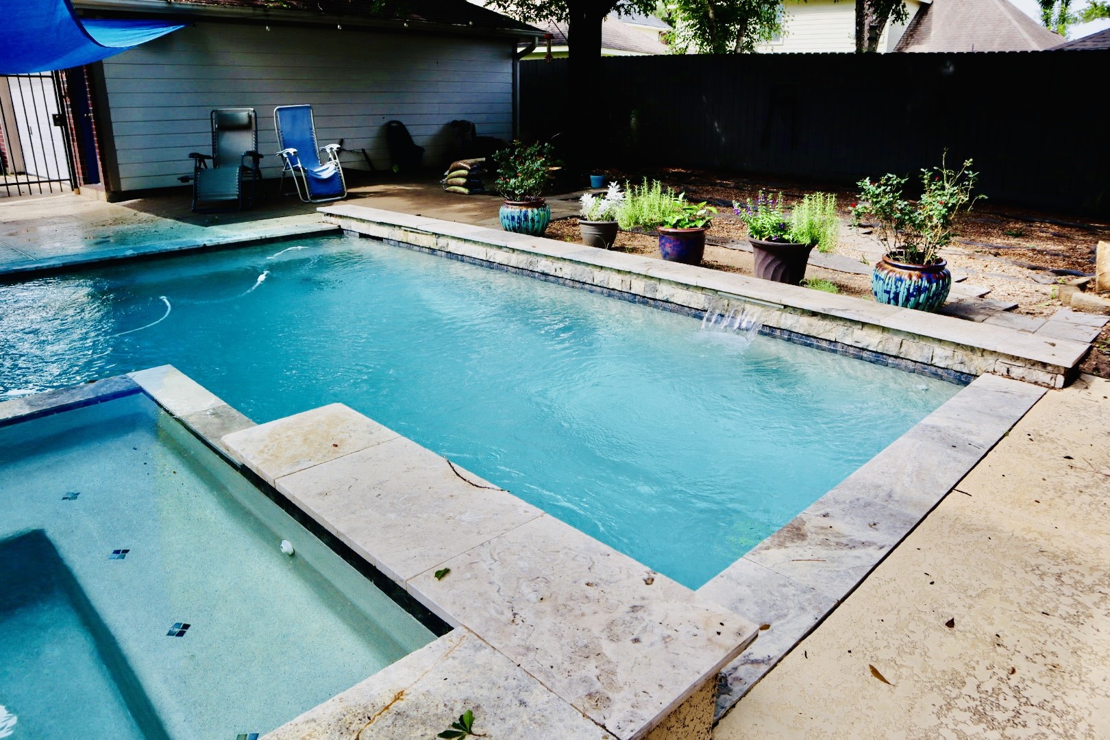 19114 Emory Trail Spring, TX 77388 - Photo 28 of 32 Your pool area features a refreshing swimming pool with a connected hot tub and waterfall feature. The surrounding patio has enough space for seating, all enclosed by a fence for privacy, creating a serene backyard oasis.