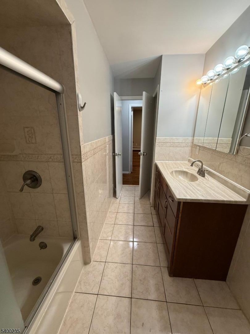 116 West Linden Avenue Linden, NJ 07036 - Photo 5 of 9 a bathroom with a sink a mirror and a bathtub