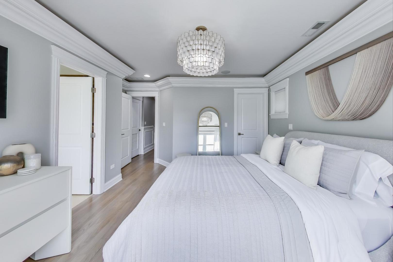 735 West Brompton Avenue, Unit 2E Chicago, IL 60657 - Photo 16 of 25 a spacious bedroom with a bed and a chandelier