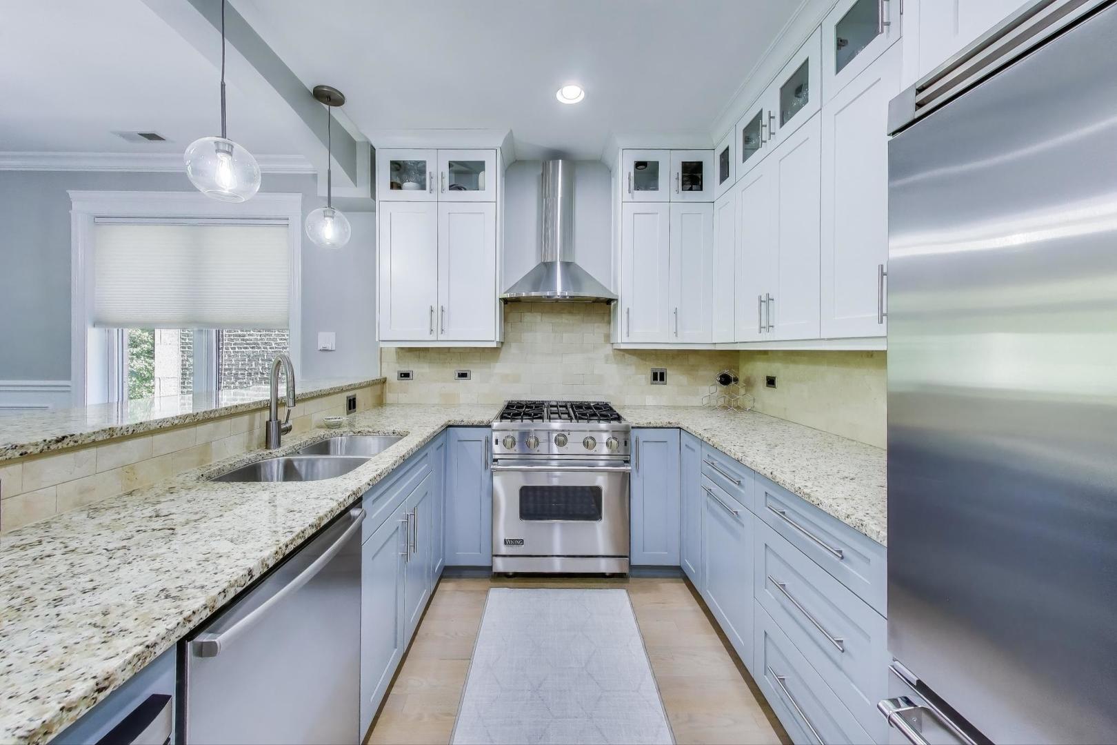 735 West Brompton Avenue, Unit 2E Chicago, IL 60657 - Photo 7 of 25 a kitchen with kitchen island granite countertop a sink stainless steel appliances and cabinets