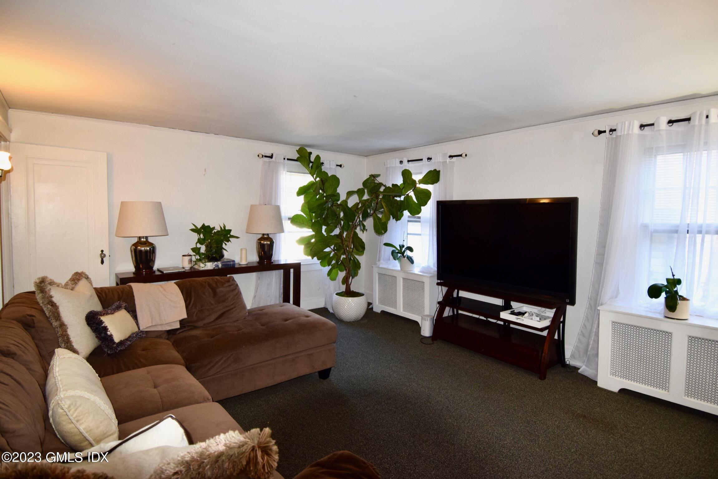 6 Pemberwick Road Greenwich, CT 06831 - Photo 23 of 32 a living room with furniture and a flat screen tv