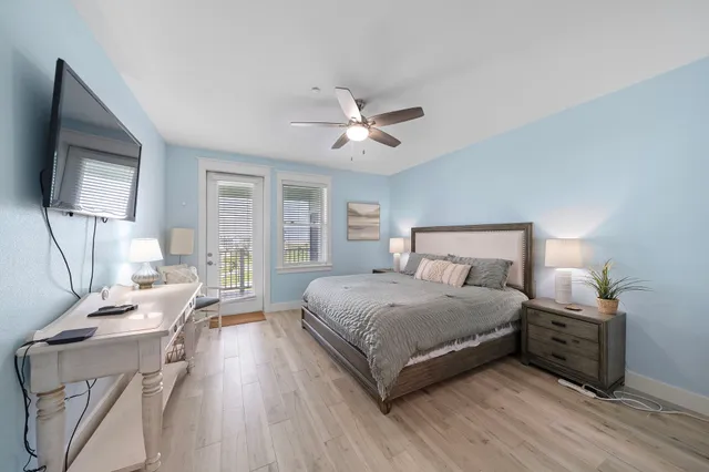 a bedroom with a bed wooden floor and a chandelier