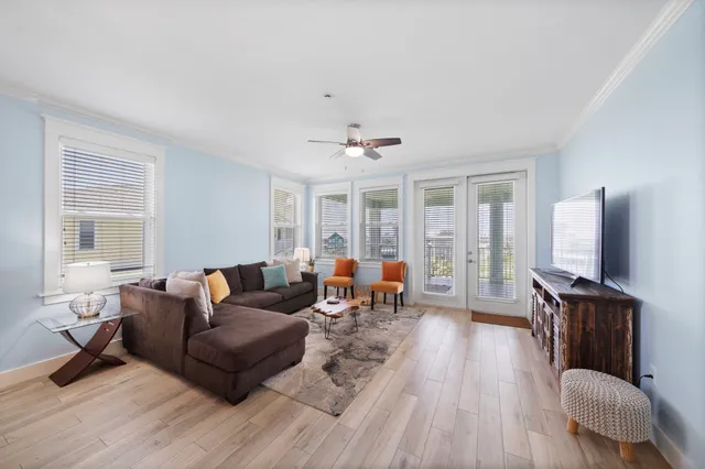 a living room with furniture a flat screen tv and wooden floor