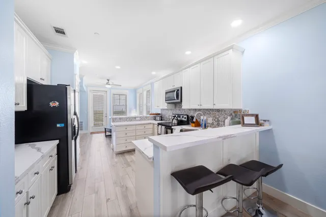 a kitchen with cabinets and wooden floor